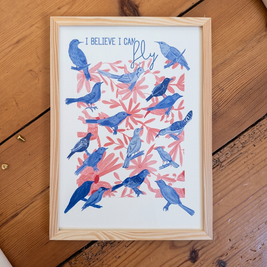 Affiche oiseaux bleus et feuillage rose encadrée dans un cadre en bois