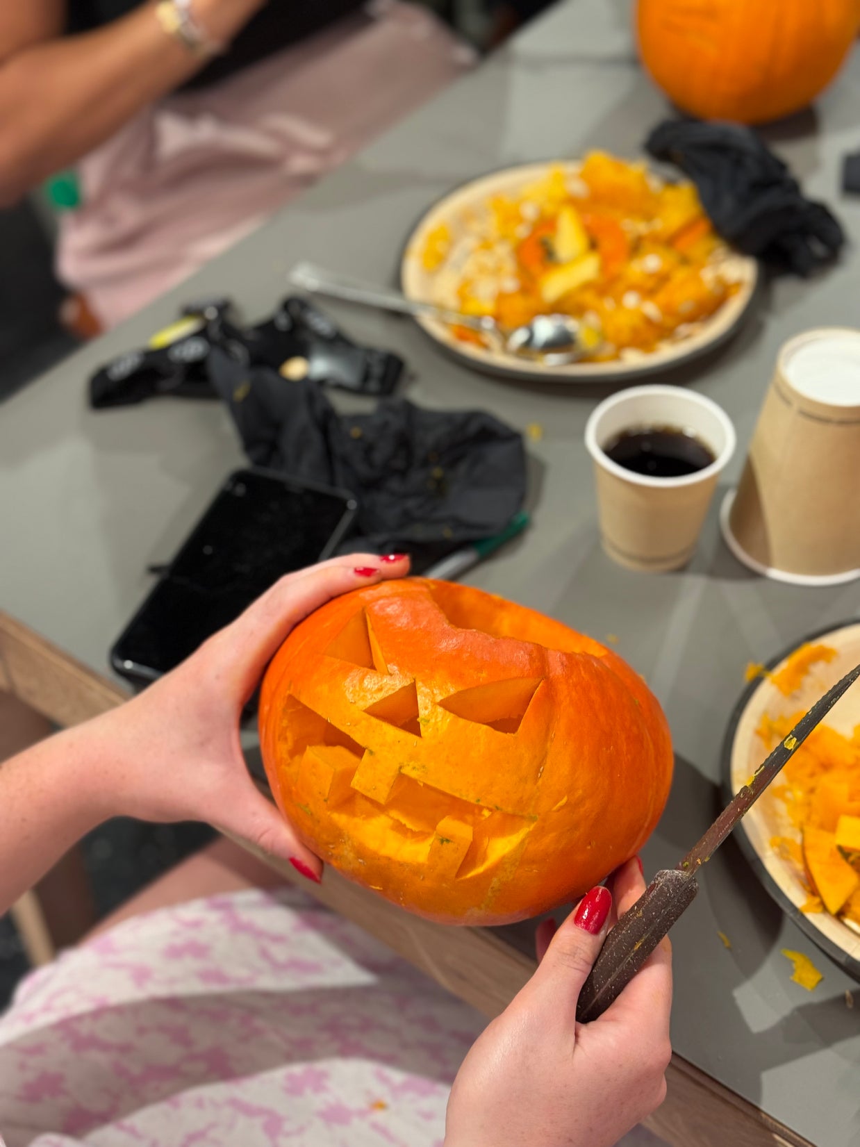 Citrouille d’Halloween sculptée avec un visage lumineux réalisée pendant un atelier pour enfants