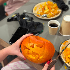 Citrouille d’Halloween sculptée avec un visage lumineux réalisée pendant un atelier pour enfants