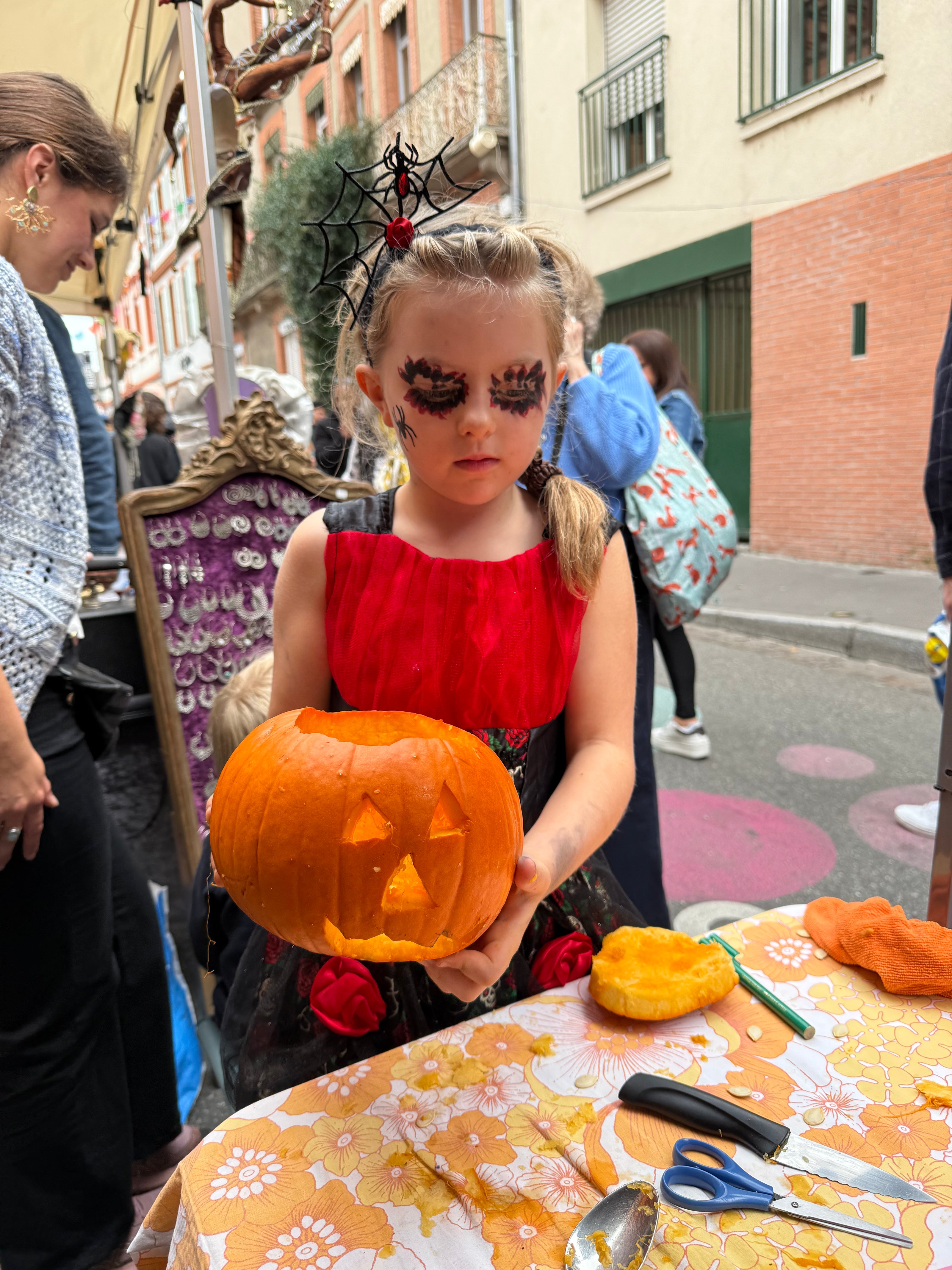 Enfant et adulte en train de découper une citrouille pour créer une lanterne d’Halloween lors d’un atelier créatif