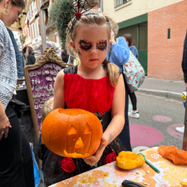 Enfant et adulte en train de découper une citrouille pour créer une lanterne d’Halloween lors d’un atelier créatif