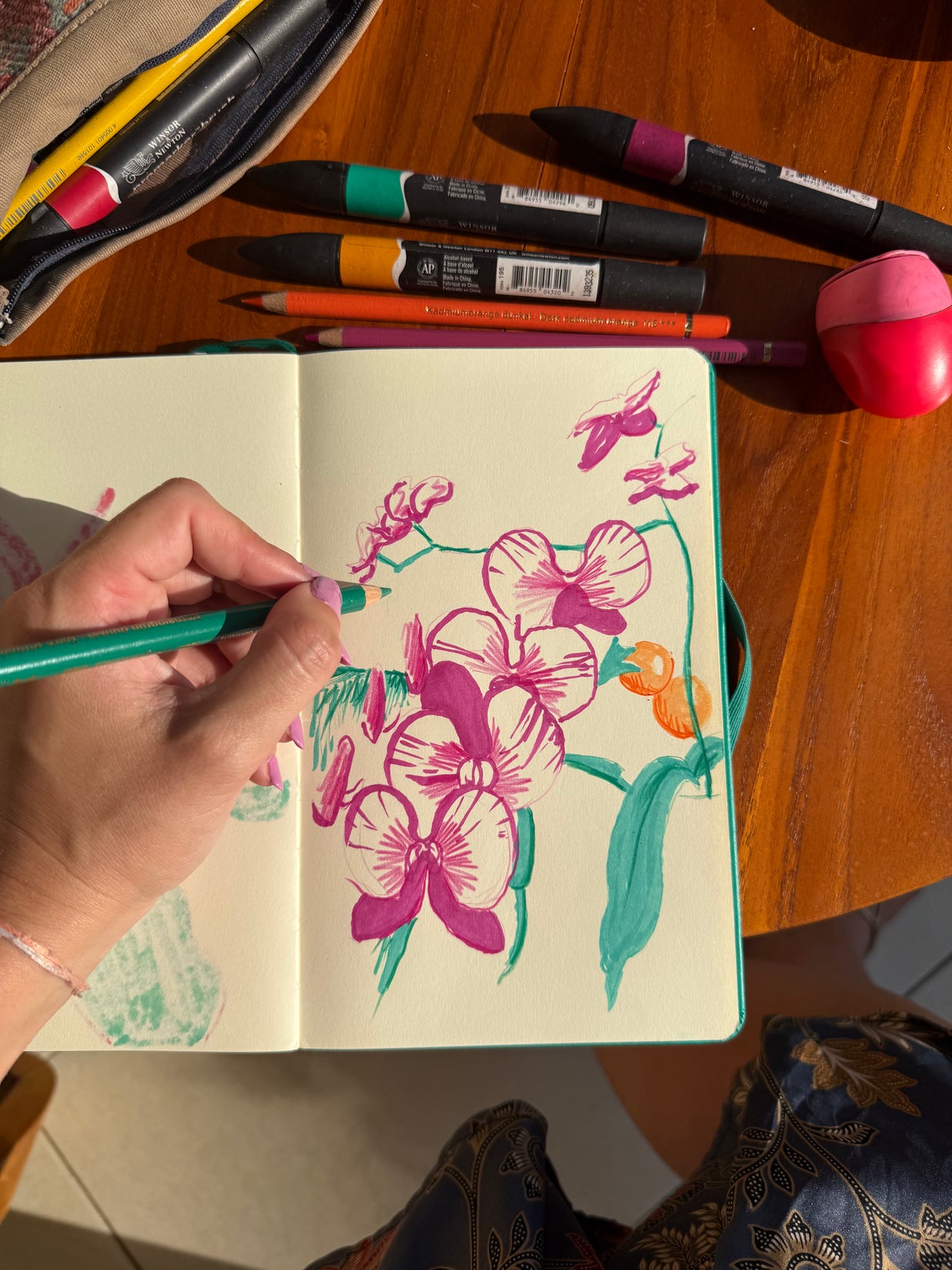 Table de travail avec dessins de plantes, crayons et références végétales pour un atelier créatif