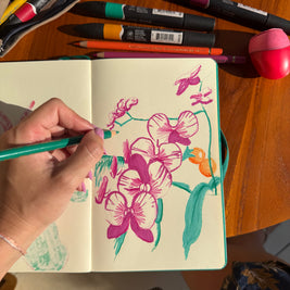 Table de travail avec dessins de plantes, crayons et références végétales pour un atelier créatif