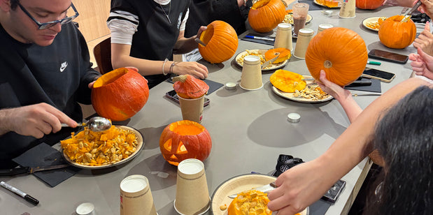 Table d’atelier avec citrouilles, outils et décorations pour créer des lanternes d’Halloween
