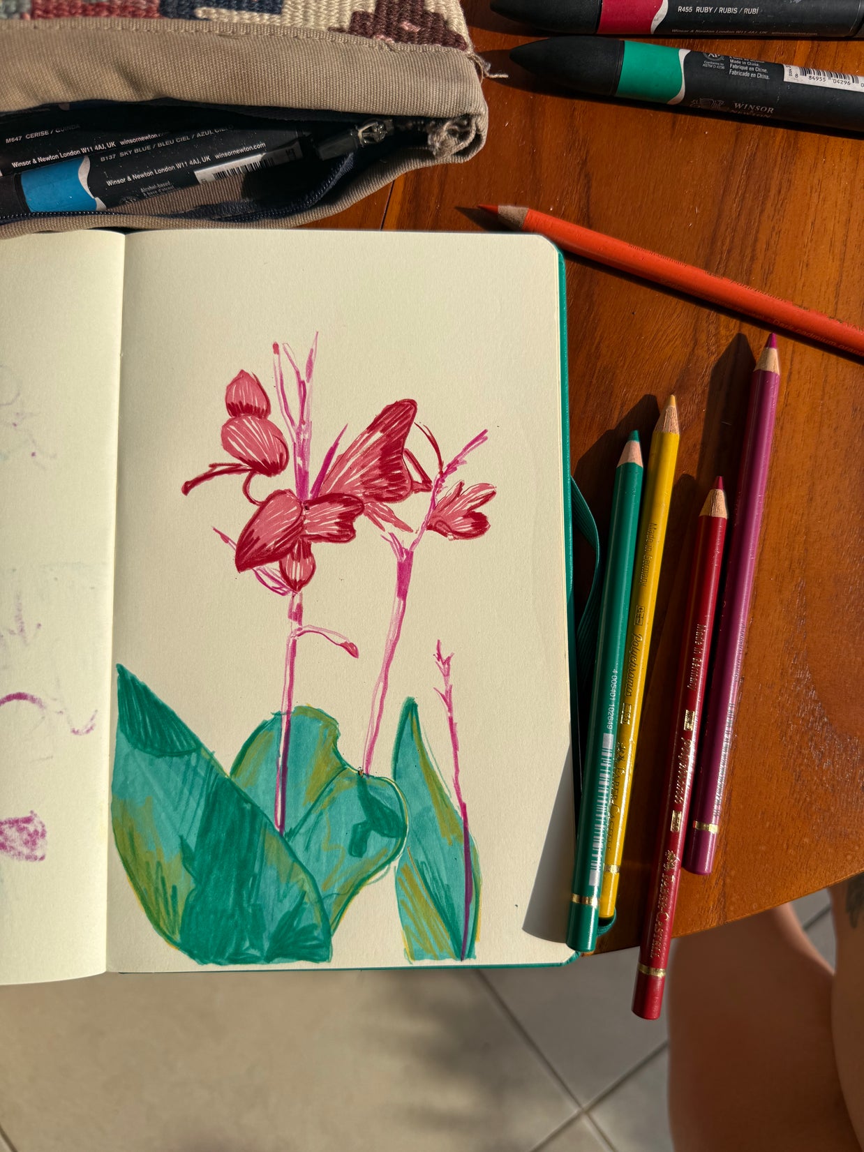 Carnet ouvert avec illustrations de feuilles et fleurs réalisées pendant un atelier artistique