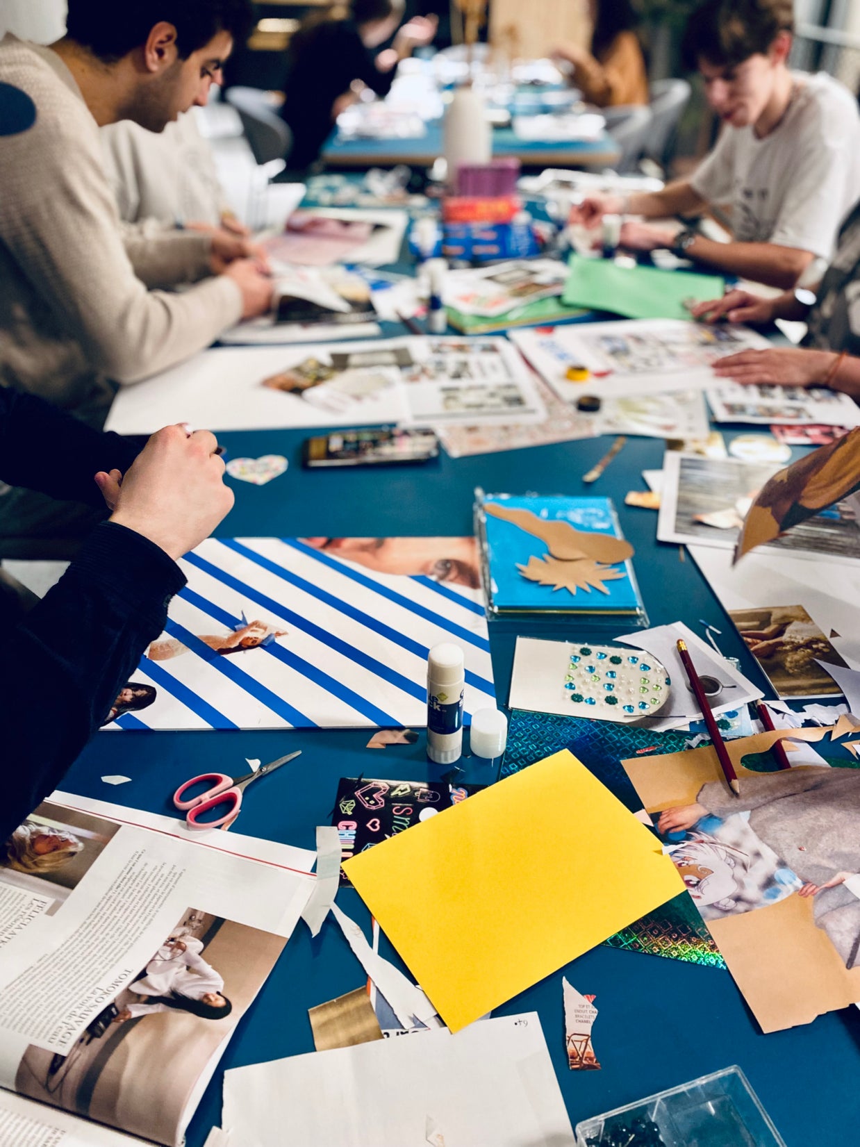 Table de travail avec images, mots inspirants et matériaux pour réaliser un visionboard personne