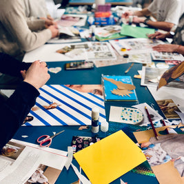 Table de travail avec images, mots inspirants et matériaux pour réaliser un visionboard personne